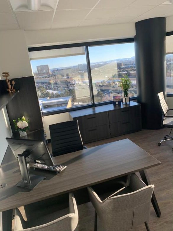 Private office with dark wood desk and city views